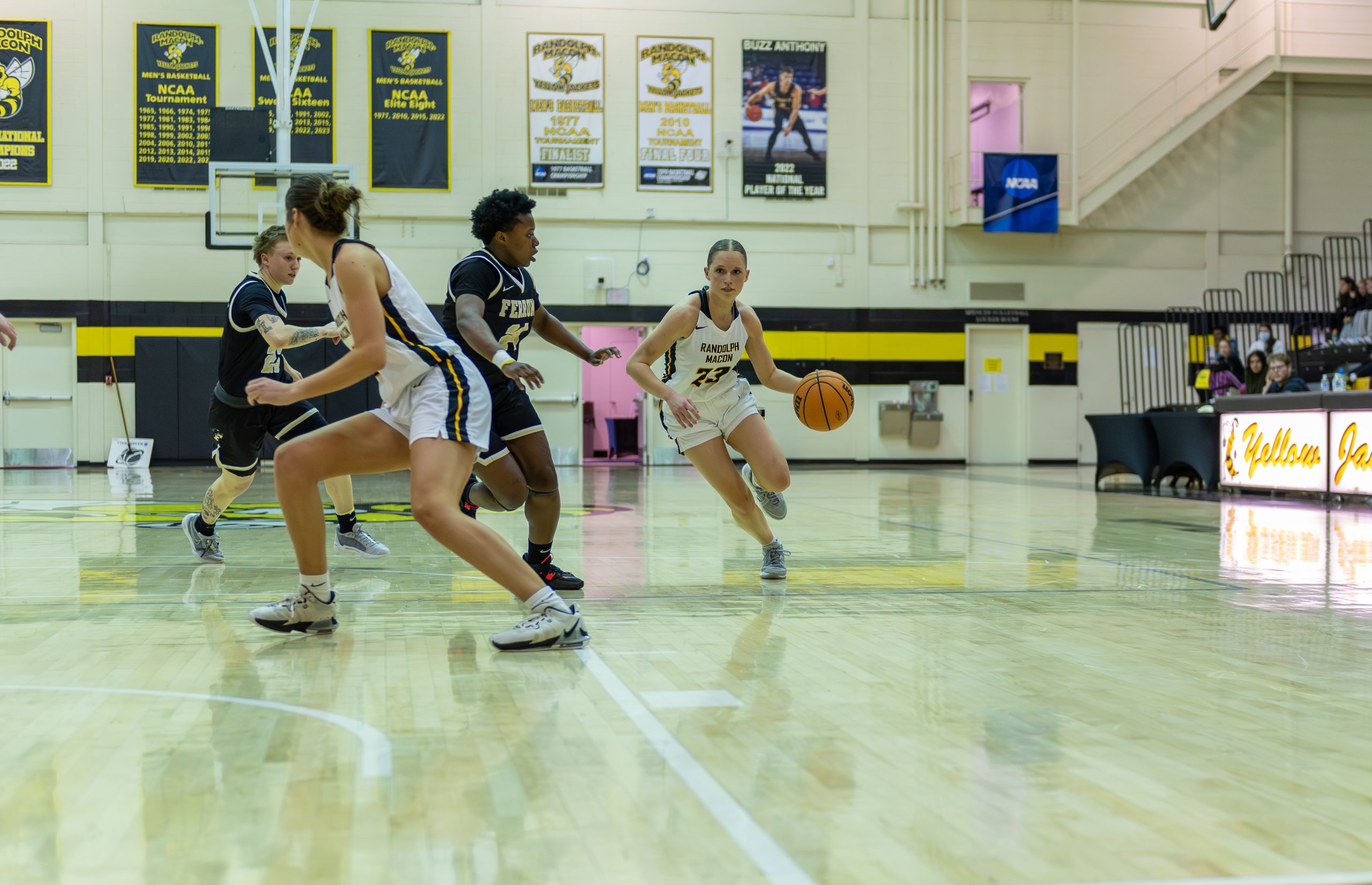 RMC basketball player dribbling the ball past a defender